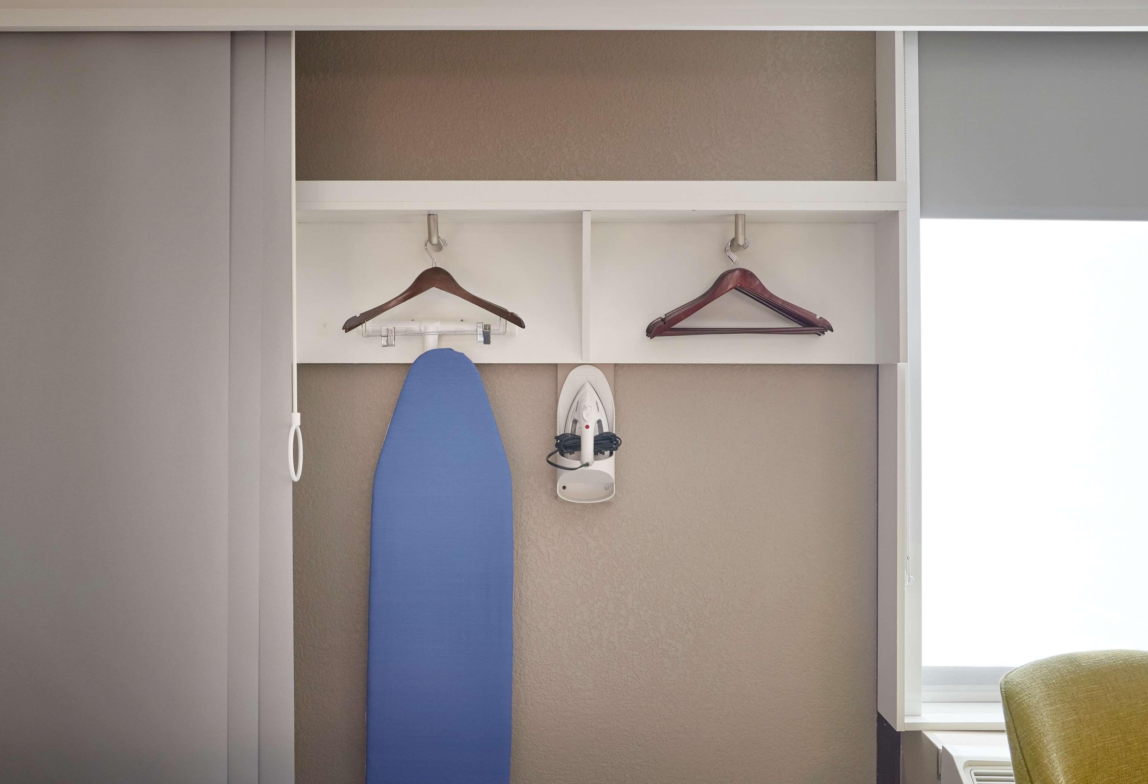 Une pièce avec un placard blanc, une planche de surf bleue et une chaussure blanche posée sur une étagère.