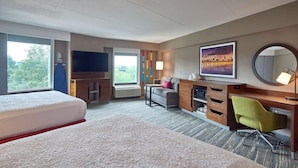 A hotel room with a large bed, a desk with a chair, a television, a window with a view, and a painting on the wall. - Hampton Inn by Hilton Harrisburg West (Mechanicsburg)