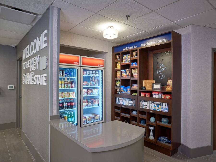 A reception area with a counter, a 'Welcome to the Key Stone State' sign, a 'Welcome to Mechanicsburg' sign, and a snack display.