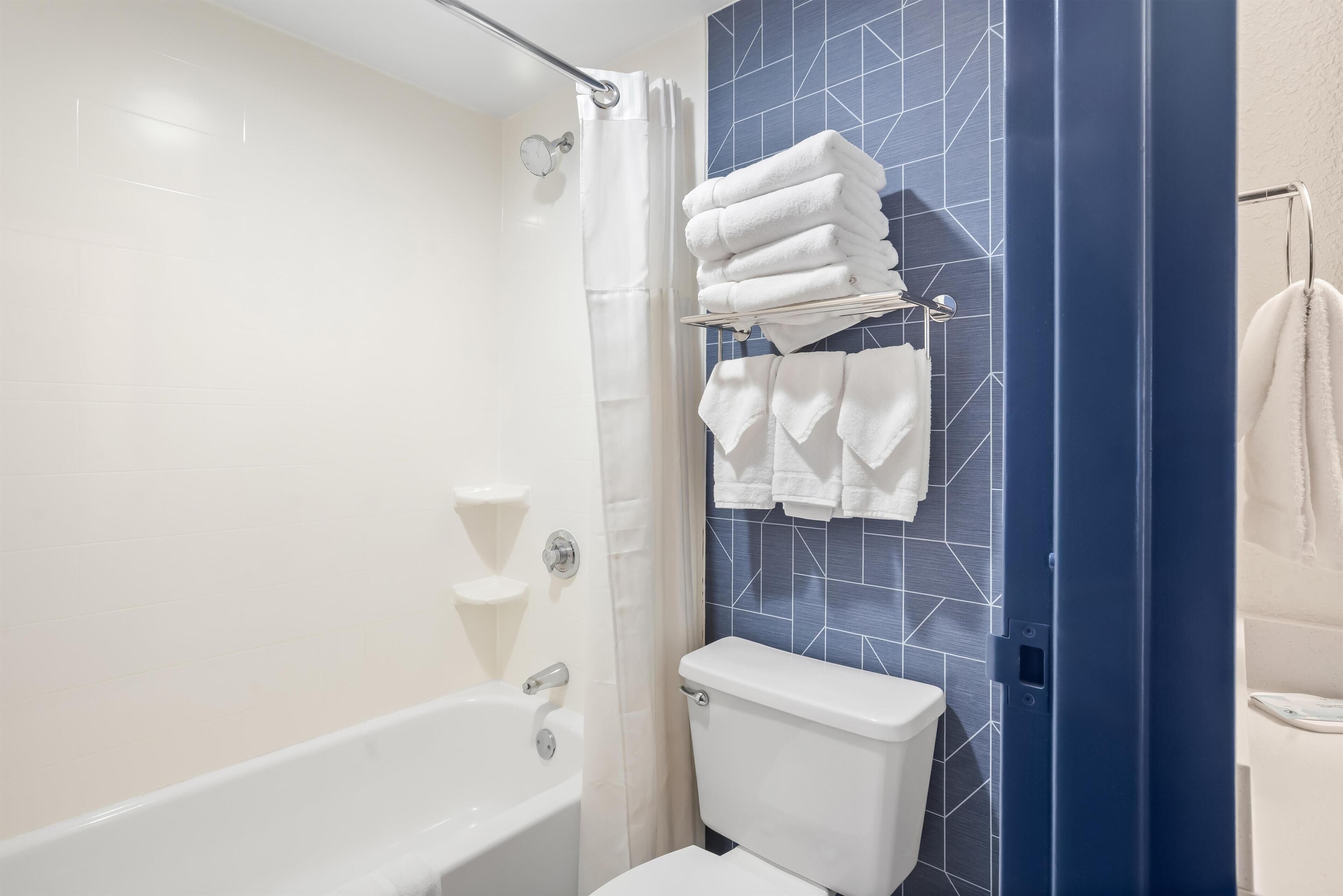 Suite, 2 queensize bedden | Badkamer | Een bad/douchecombinatie, gratis toiletartikelen, een haardroger