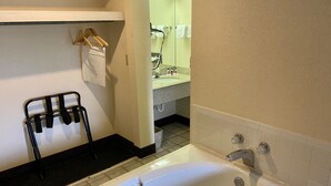 A bathroom with a bathtub, a towel rack, and a mirror. - Days Inn by Wyndham Morehead (Morehead)