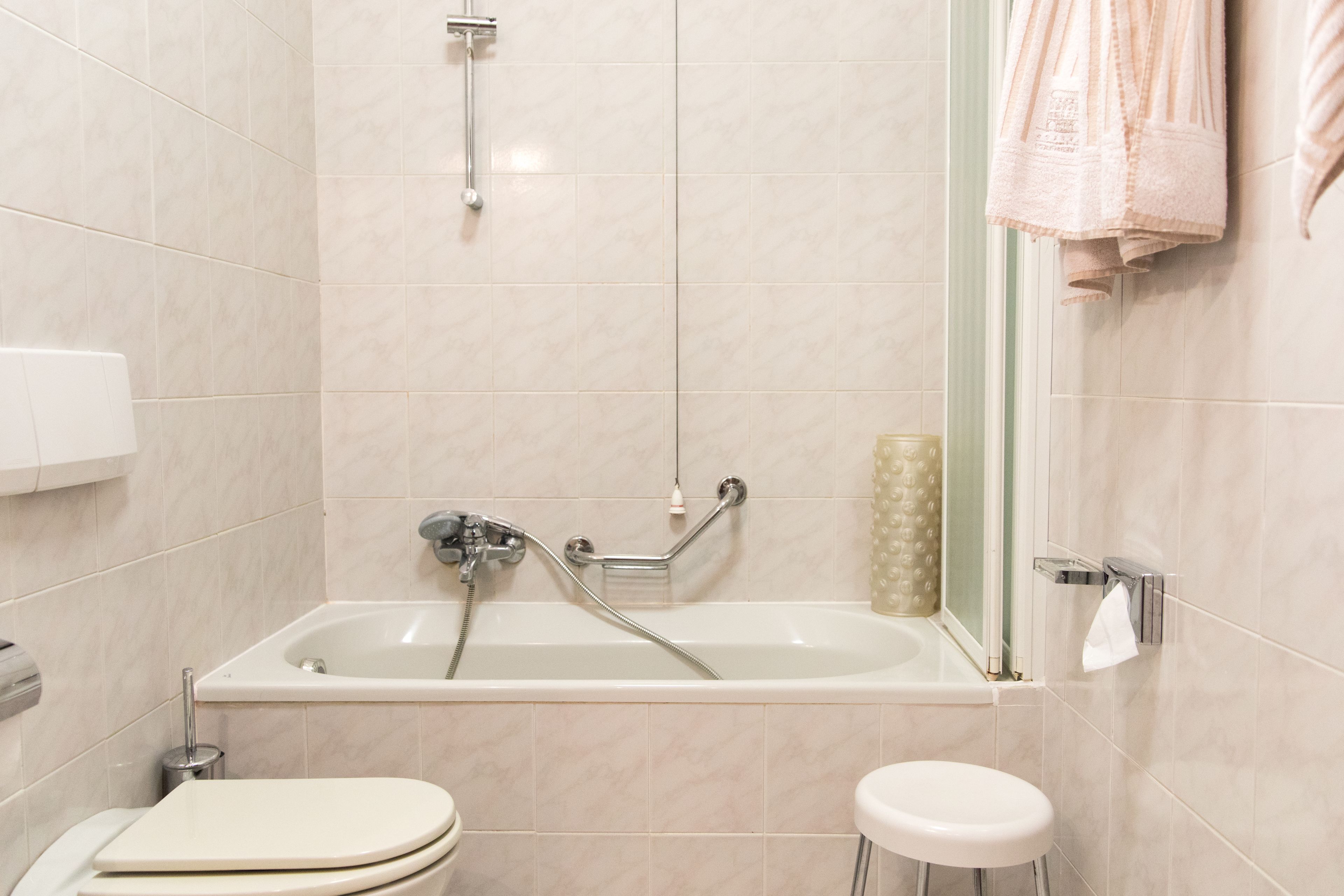 A modern bathroom with a bathtub, toilet, and a sink.