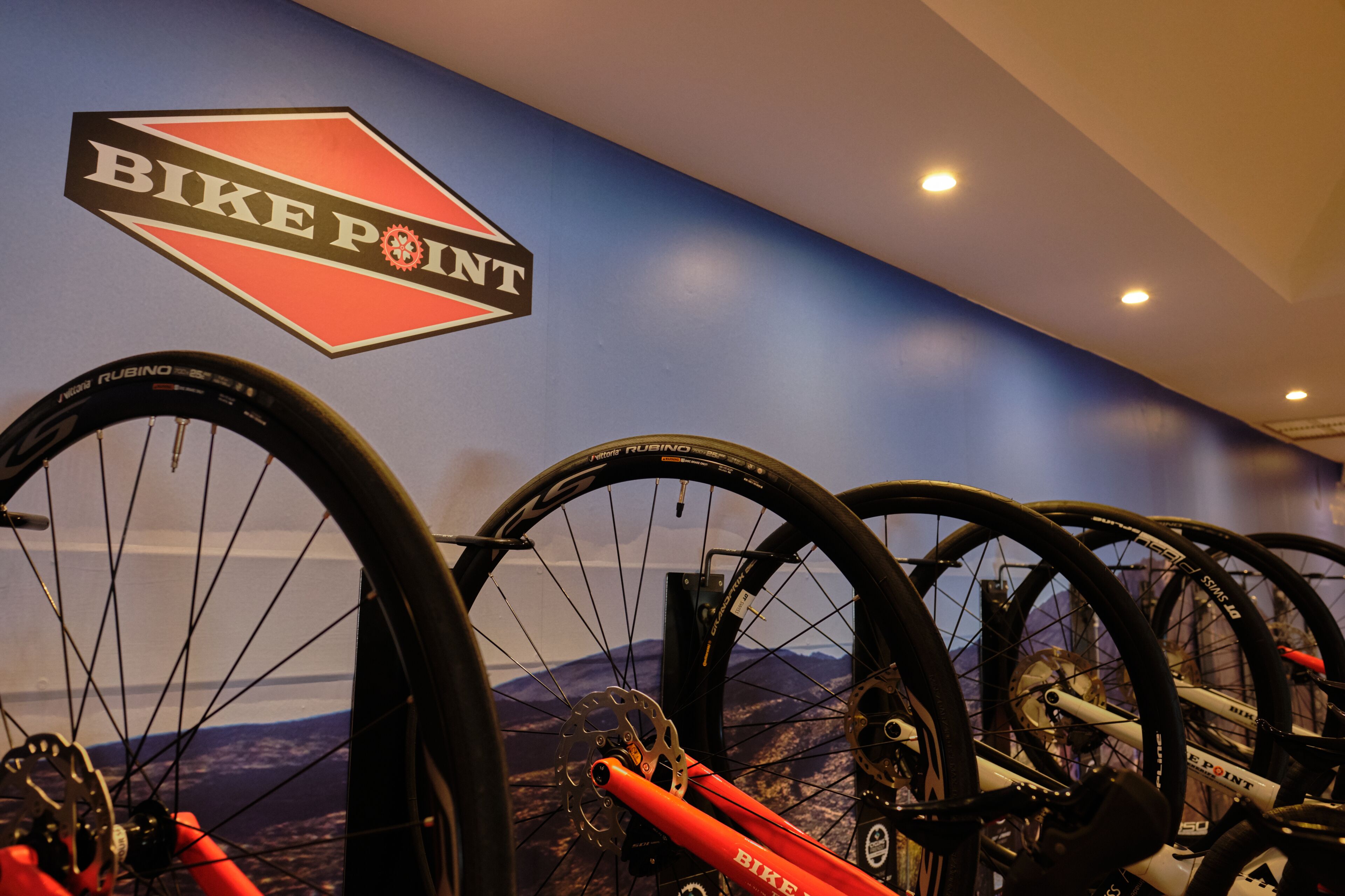 A wall with a 'BIKE POINT' sign and multiple bicycles.