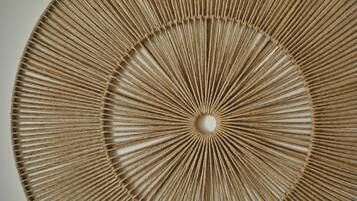 Une décoration murale circulaire ornée d’un motif radial de cordes.