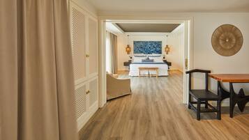 Une chambre d’hôtel avec un plancher en bois, un lit avec une tête de lit bleue et blanche, un banc en bois et un élément décoratif fixé au mur.