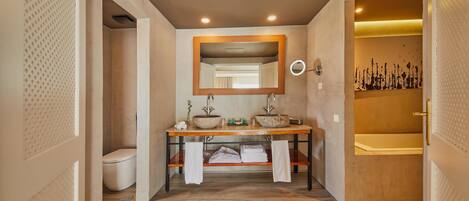 A modern bathroom with a wooden vanity, a large mirror, and a bathtub.