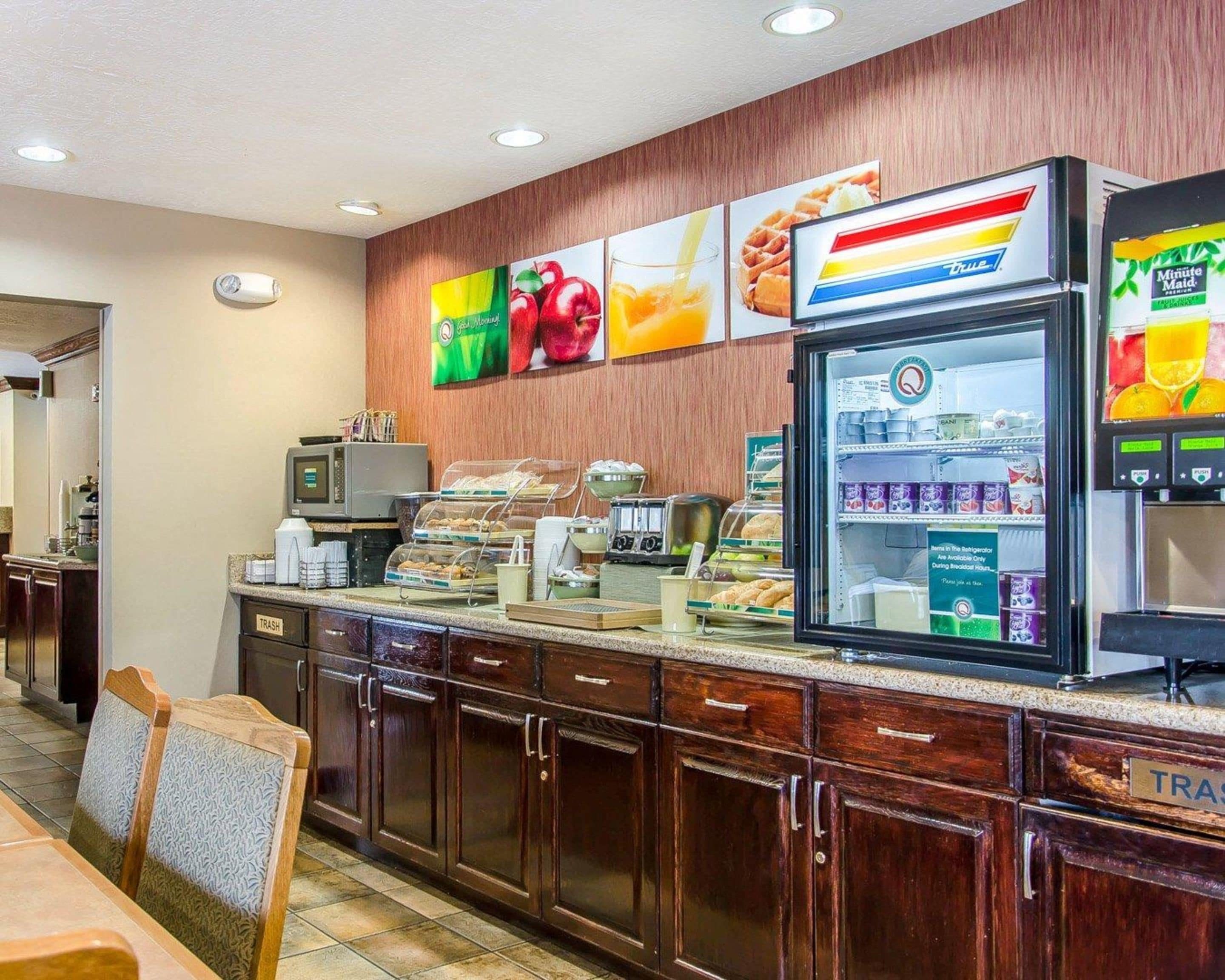 A breakfast bar with a refrigerator, microwave, and various food items.