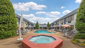 Un hotel con dos piscinas, un jacuzzi y zona de estar al aire libre.