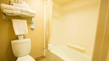 A bathroom with a toilet, a bathtub, and a towel rack with folded towels.