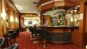 A bar area with a counter, bar stools, and a carpeted floor. - Tower Genova Airport Hotel & Conference Center (Genoa)