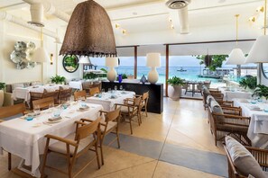 A restaurant with multiple tables, chairs, and a view of the sea. - InterContinental Presidente Cozumel Resort Spa by IHG (Cozumel)