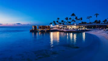 Pantai pribadi, pasir putih, payung pantai, dan handuk pantai