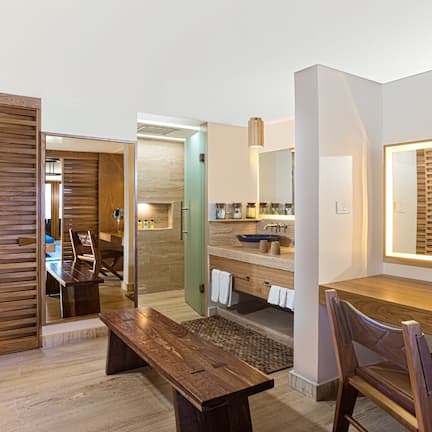 A modern bathroom with a wooden vanity, a sink, and a mirror.
