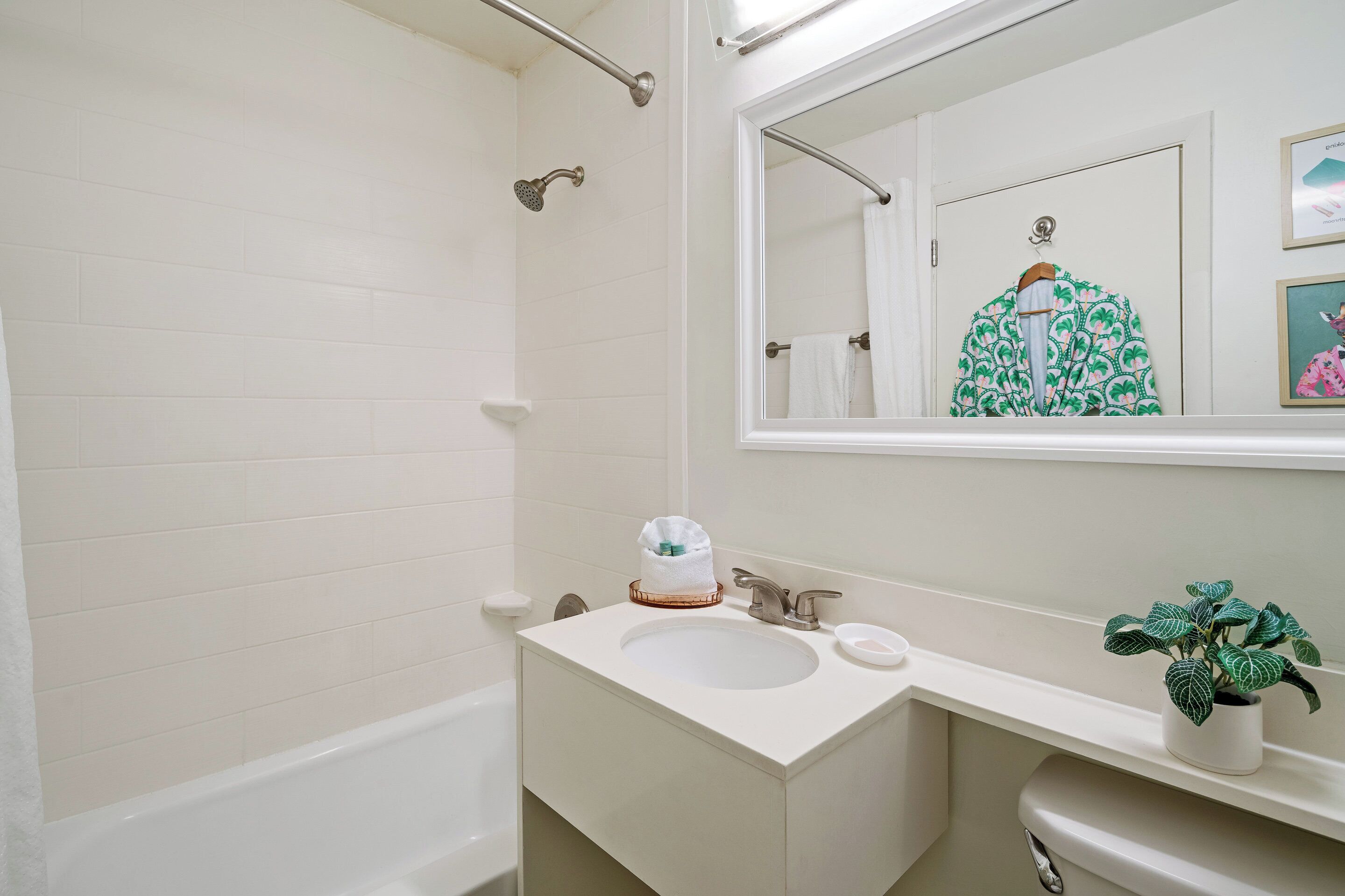 A bathroom with a white bathtub, a sink with a mirror above it, and a toilet.