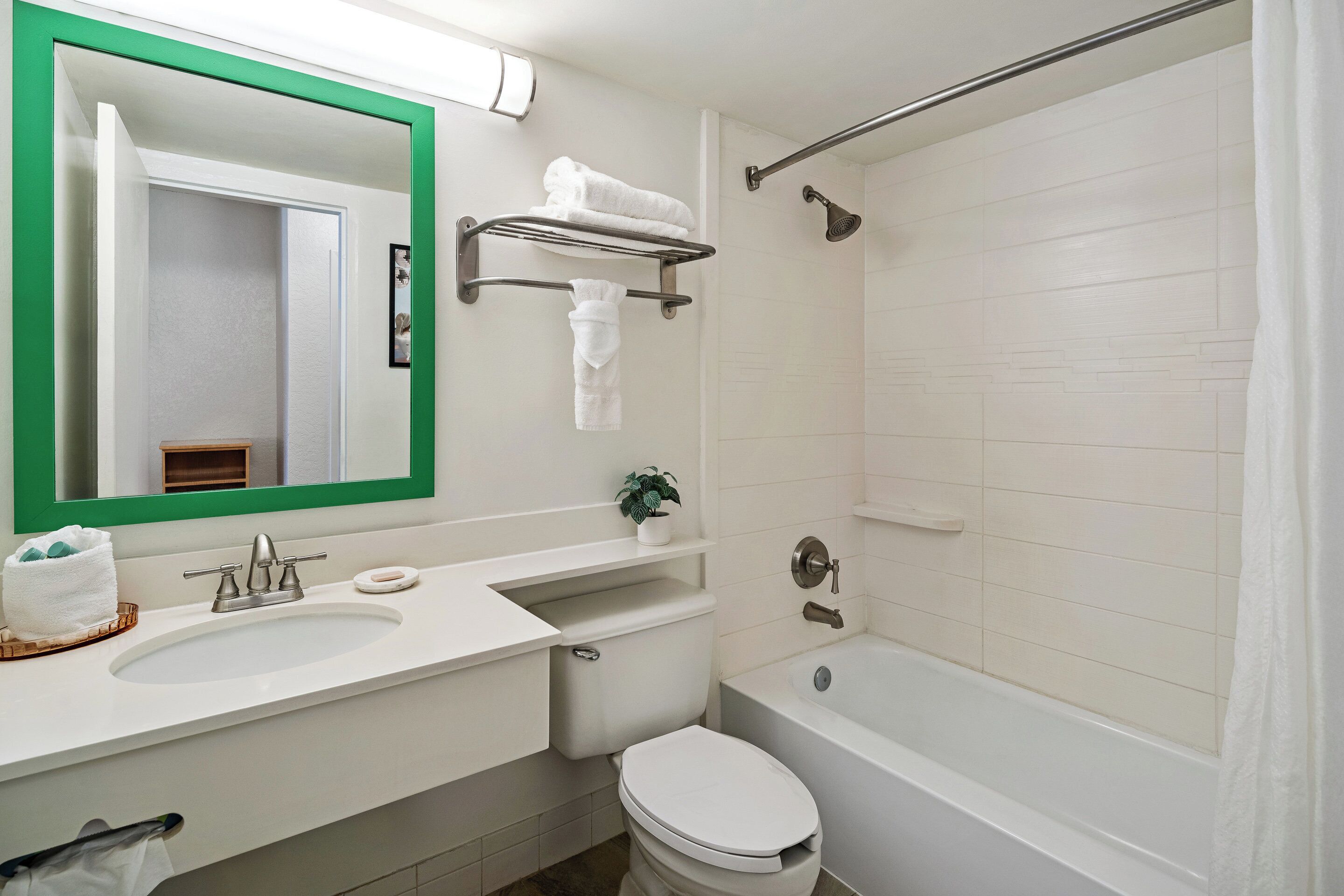 A bathroom with a white sink, a toilet, a bathtub, and a shower area.