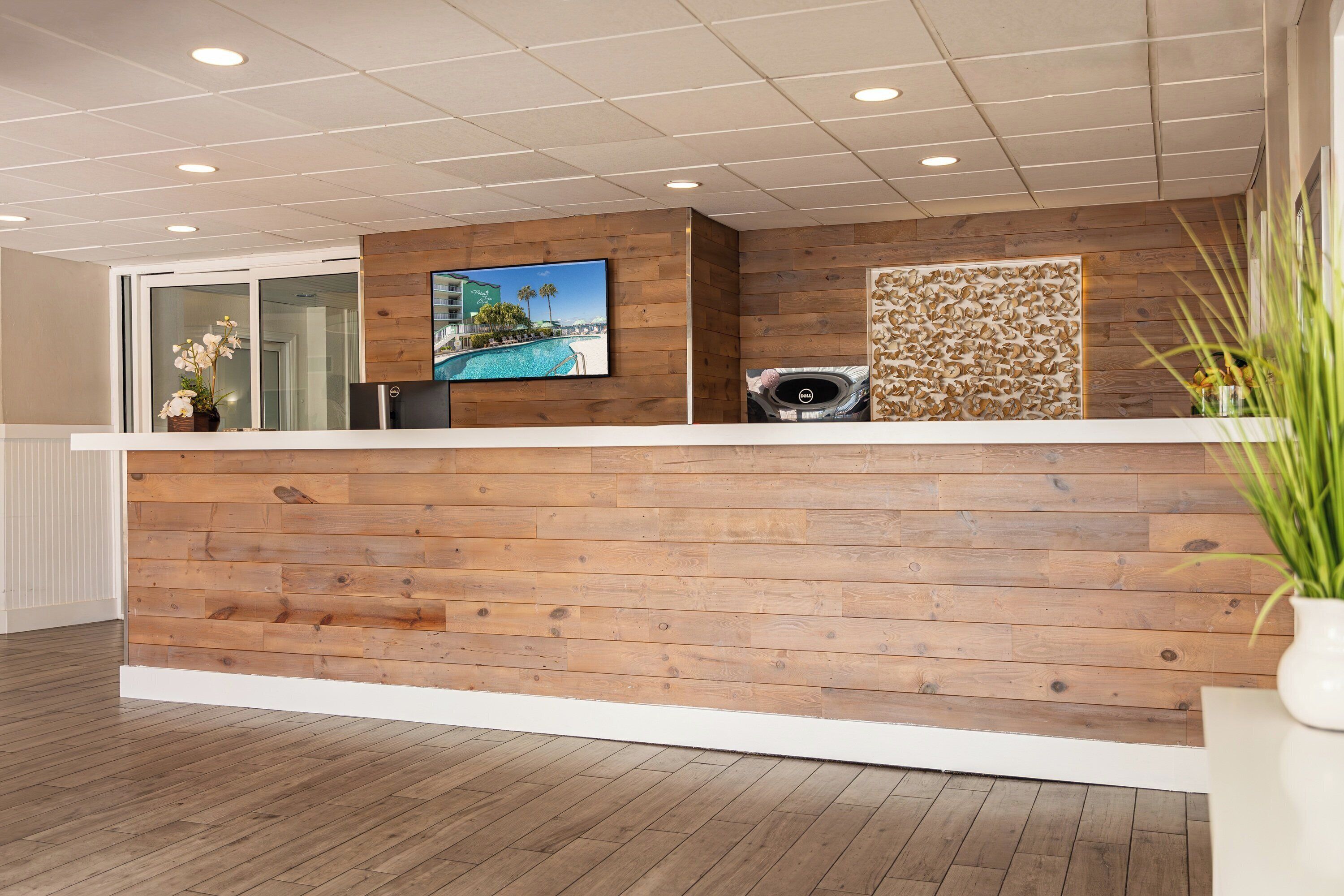 Una recepción con un diseño de panel de madera, una pantalla de televisión y un panel decorativo en la pared.
