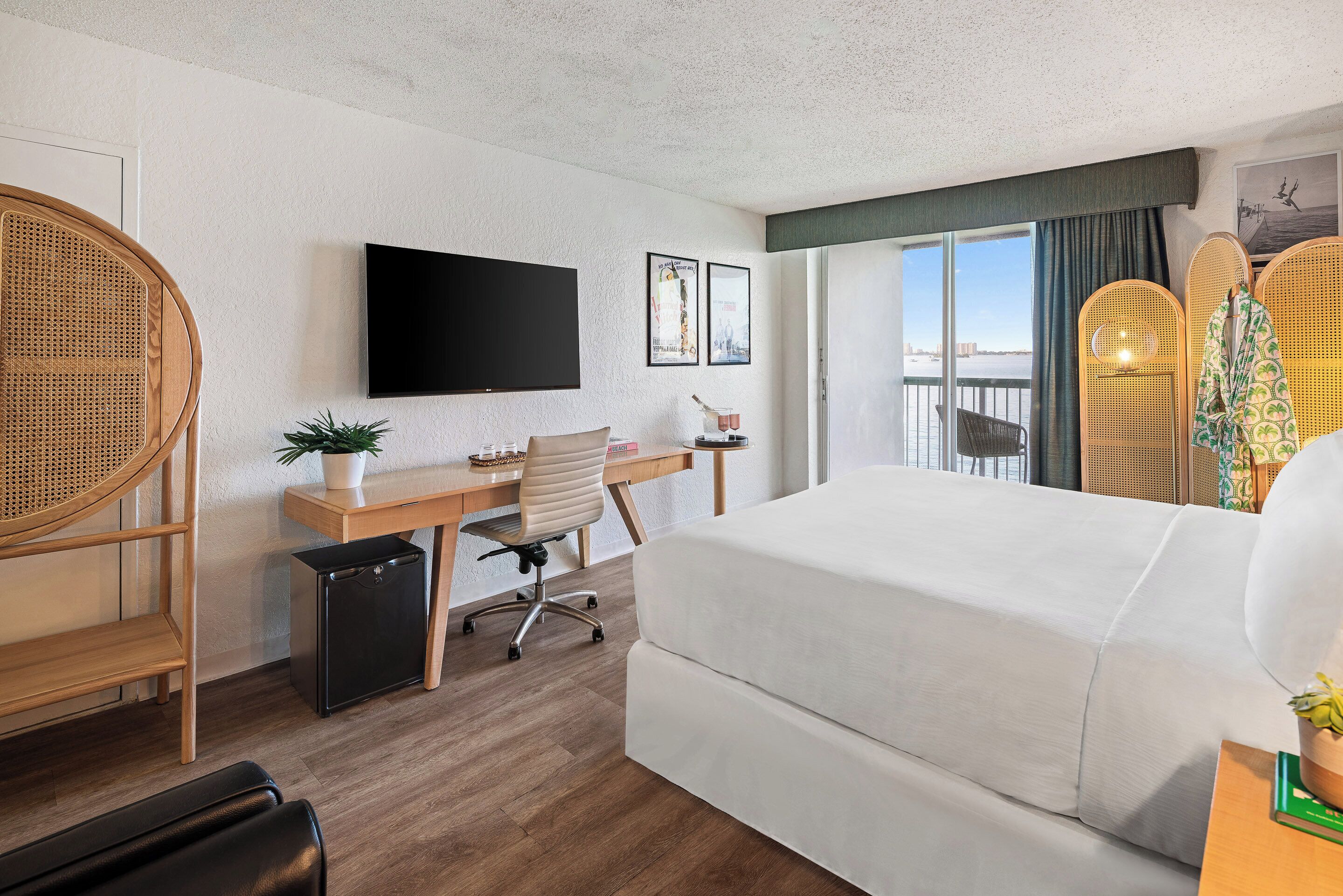 Een hotelkamer met een bed, bureau, stoel, televisie en uitzicht.
