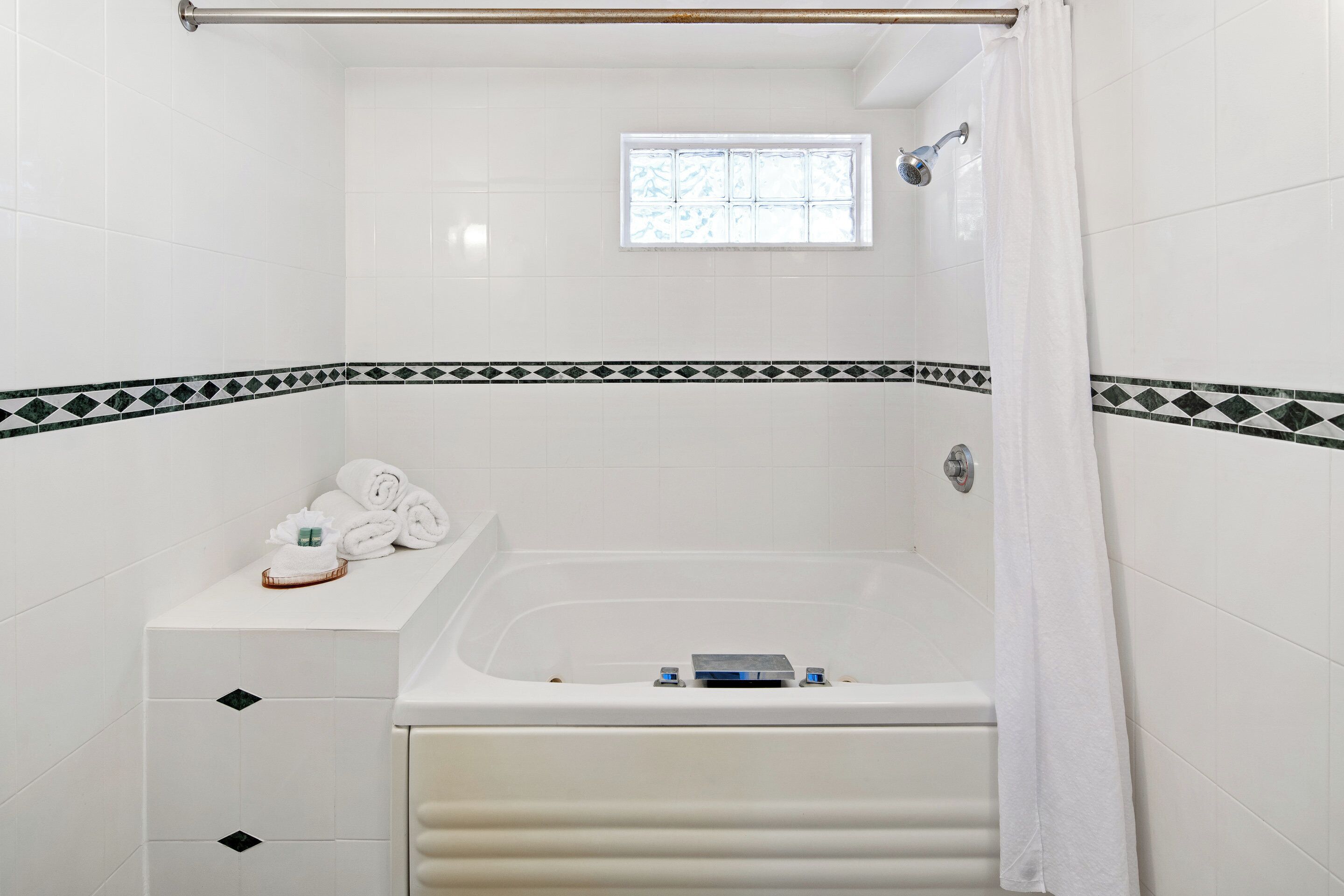 Une salle de bain avec une baignoire, une fenêtre et un porte-serviettes avec des serviettes.