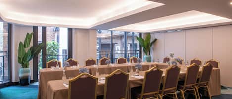 A conference room with a long table, chairs, and large windows.