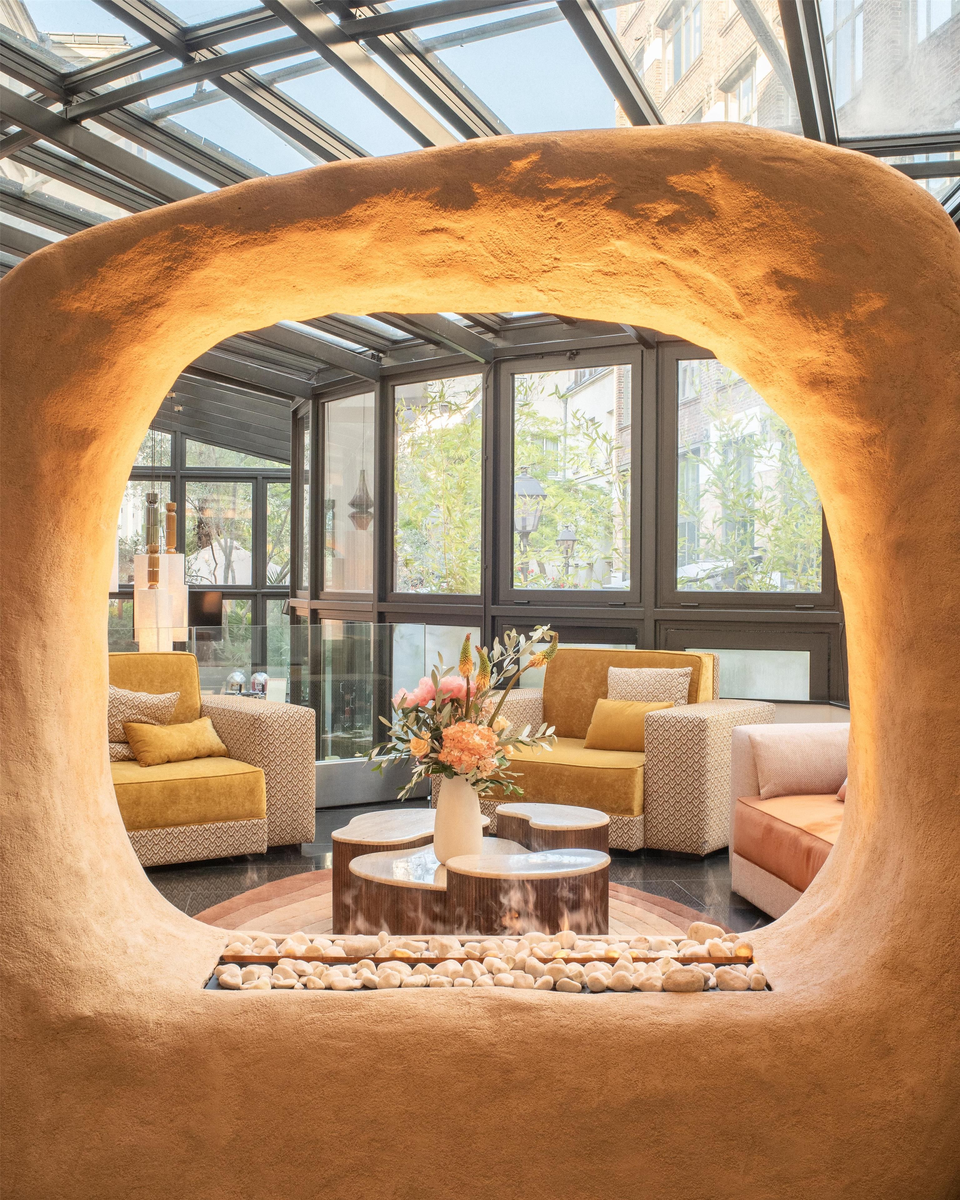 A modern interior with a unique arch structure, seating arrangements, and a central table with a vase of flowers.