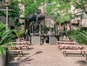 A courtyard with a gazebo, picnic tables, and potted plants. - Les Jardins du Marais (Paris)