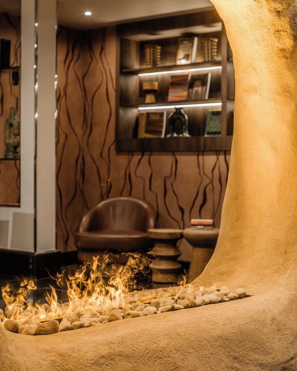 Angolo relax con camino, sedute e libreria.