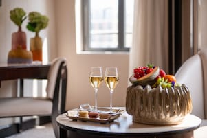 A table with a cake, two glasses of white wine, and a tray of macarons.