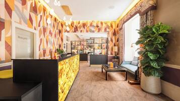 A reception area with a modern design, featuring a reception desk, seating area, and a large potted plant.