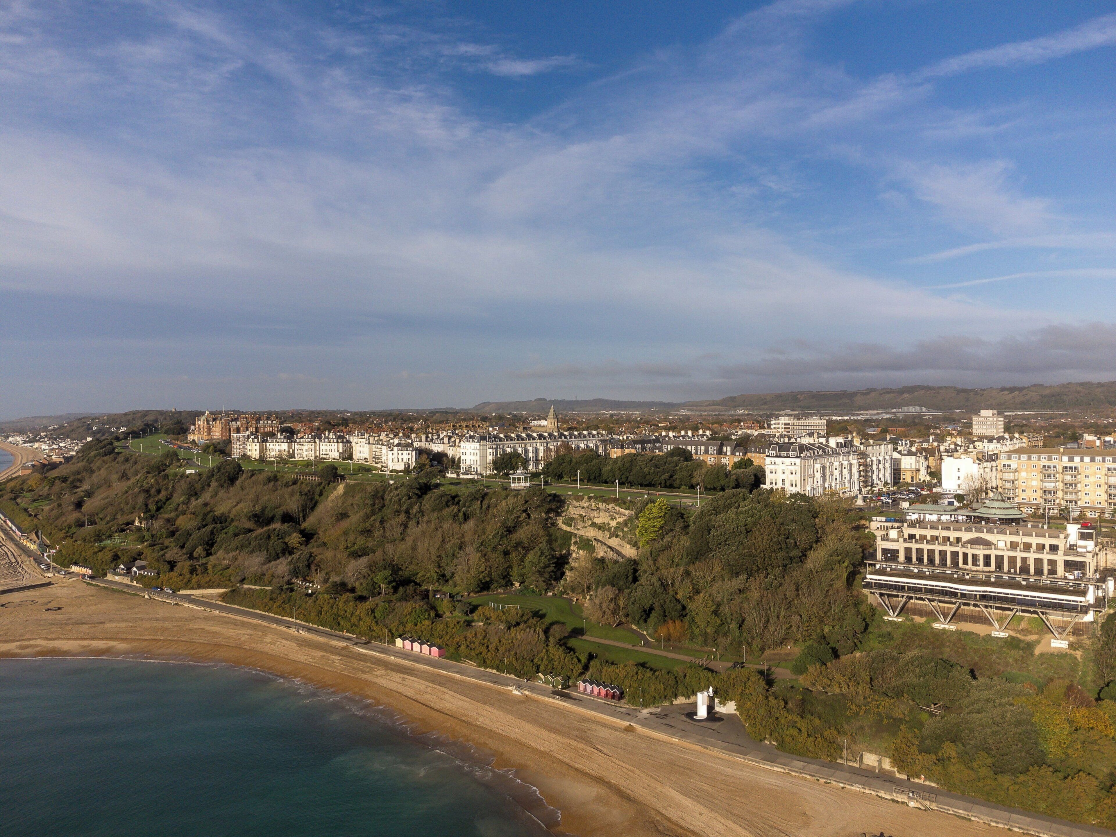 A coastal cityscape with a prominent castle-like building, a beach, and a mix of residential and commercial buildings.