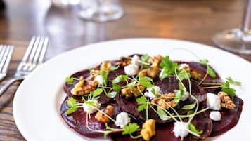 A plate of beetroot salad with walnuts and cheese on a wooden table.