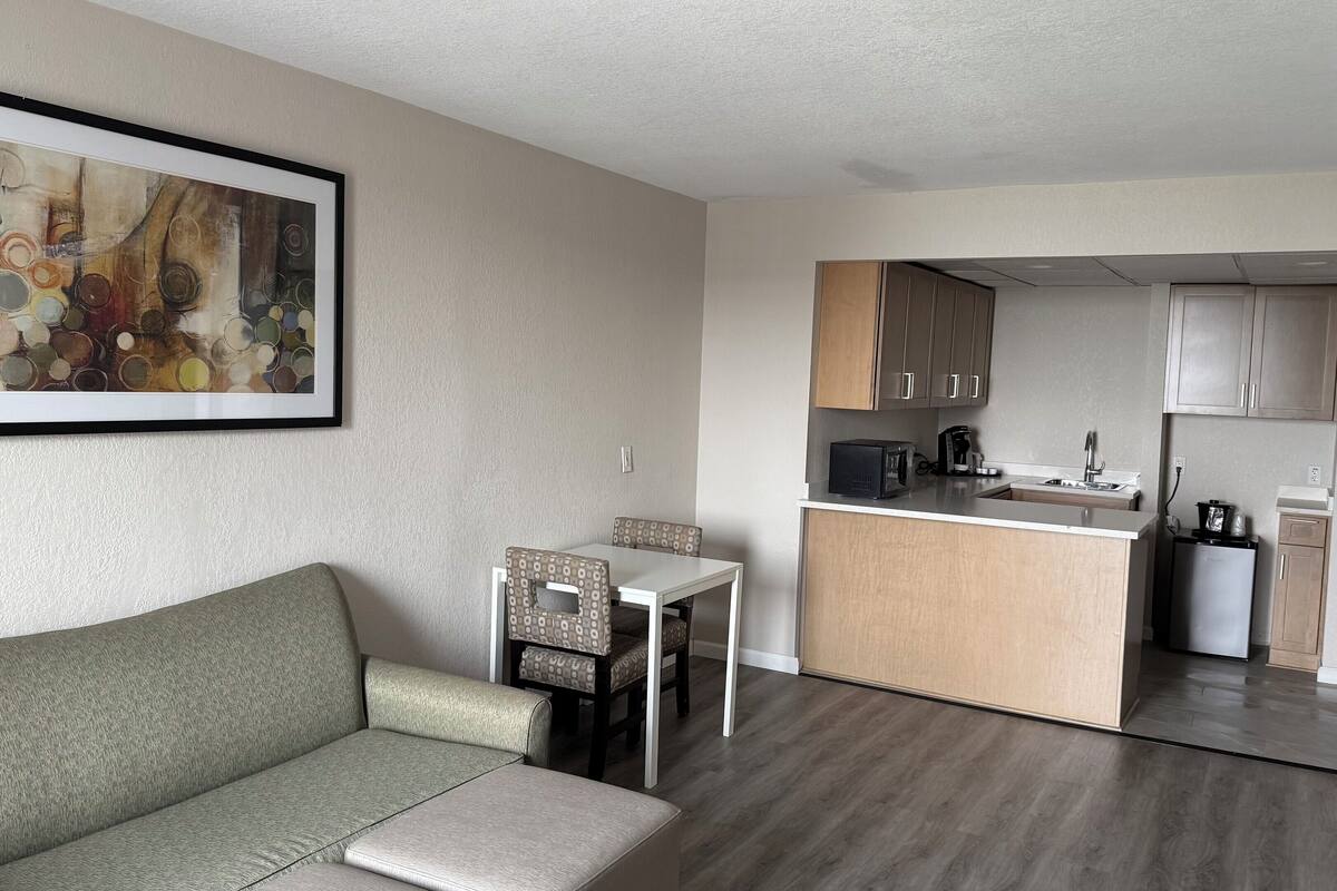 A compact living space with a sofa, a dining table, and a kitchenette.