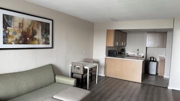 A compact living space with a sofa, a dining table, and a kitchenette.