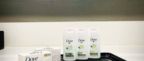Dove beautyzeep, Dove shampoo, Dove conditioner en Dove douchegel op een dienblad.