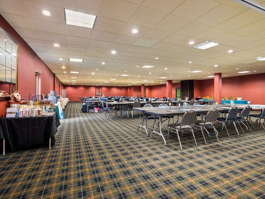 A conference room with tables, chairs, and a carpeted floor.