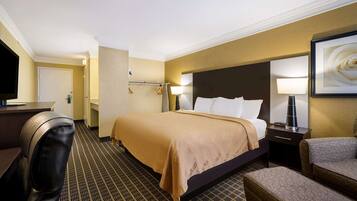 Une chambre d’hôtel avec un lit, un bureau, une chaise et un téléviseur.