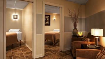 A hotel room with a bed, a sofa, a small table with a lamp, and a decorative vase.