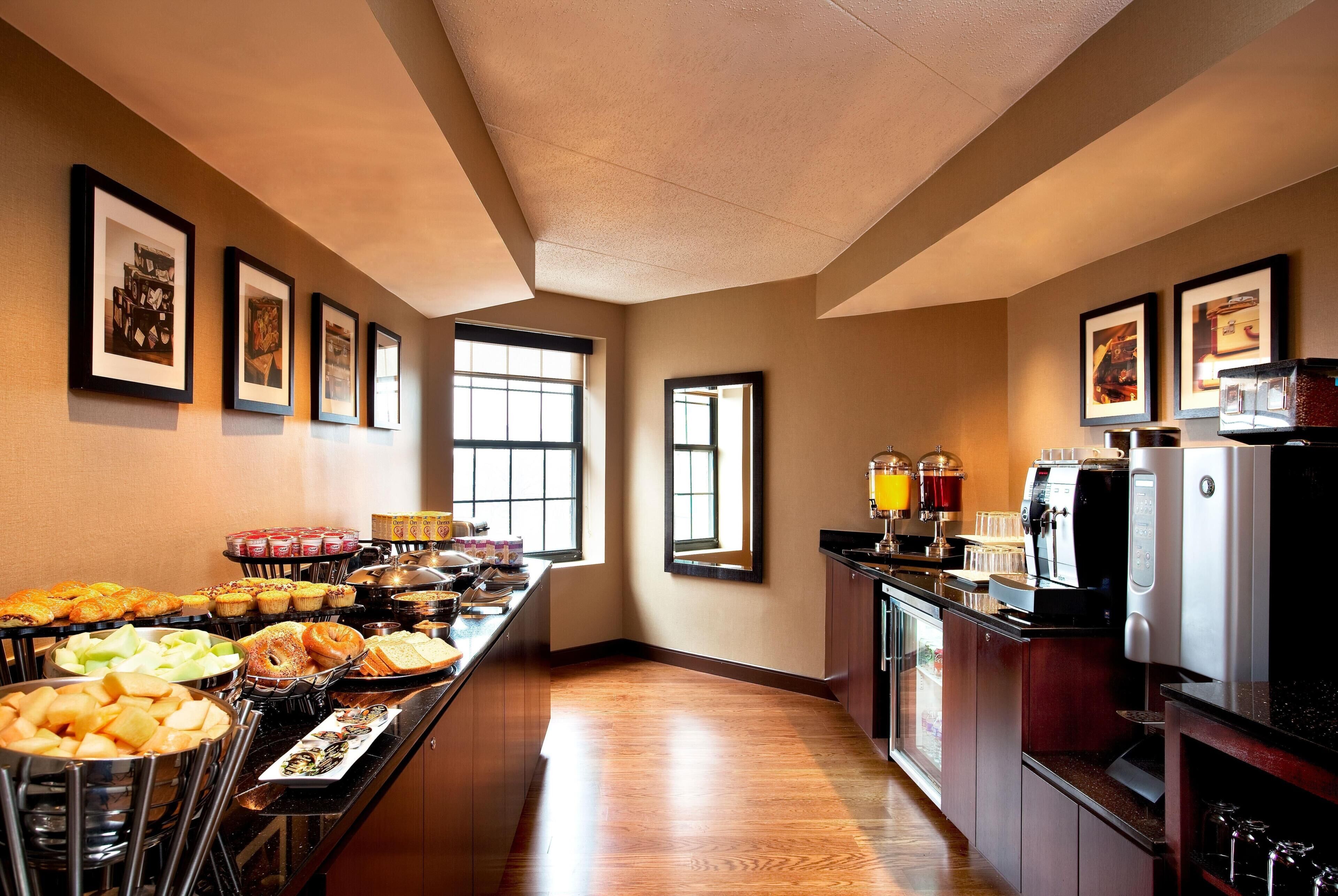 A hotel kitchen with a buffet setup, including various food items and a coffee machine.