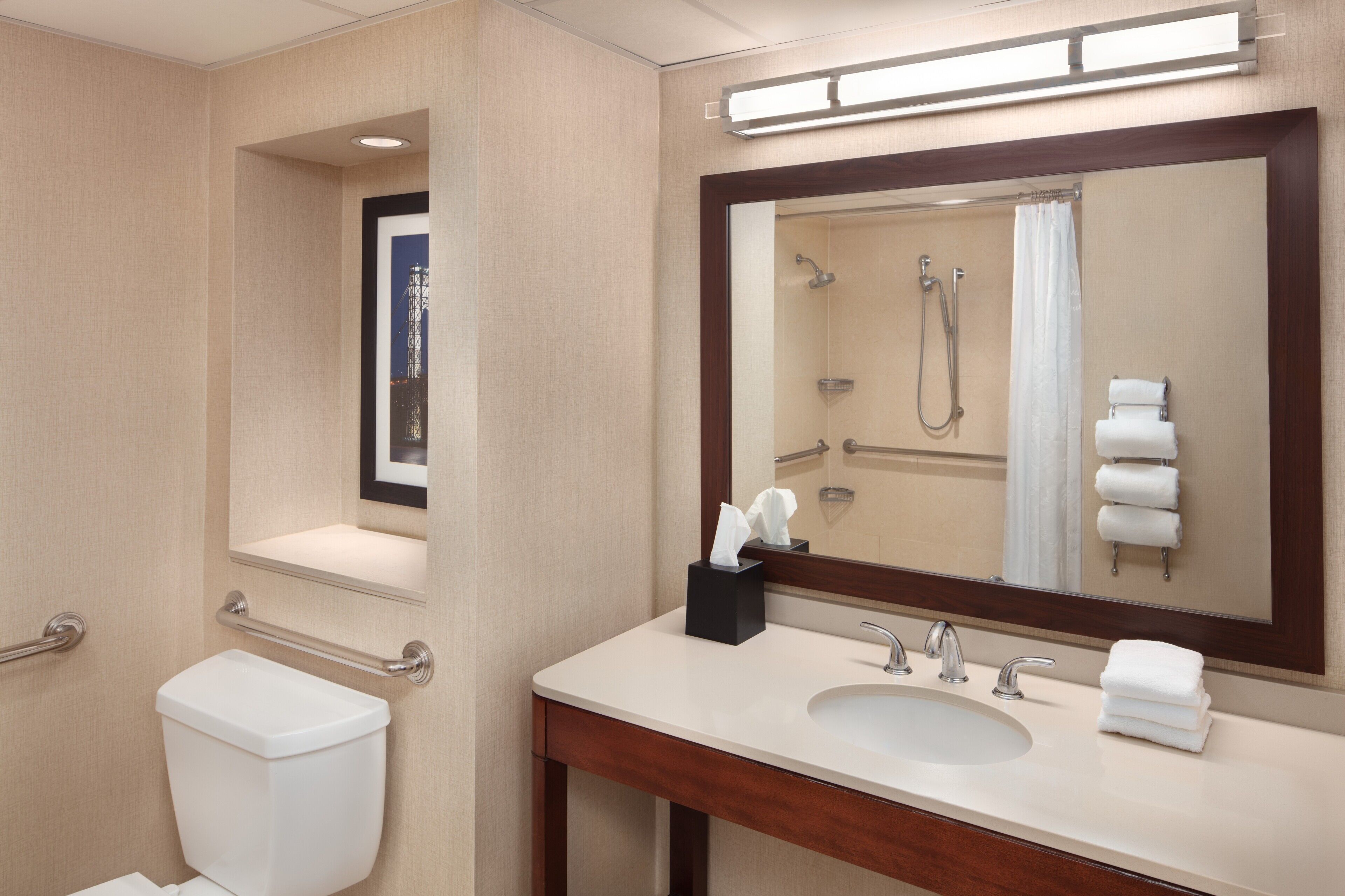 Un baño de hotel con inodoro, lavamanos y ducha.