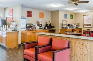 A hotel kitchen with a breakfast bar, seating area, and various appliances. - Sleep Inn Idaho Falls I-15 (Idaho Falls)