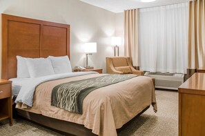 A hotel room with a bed, a chair, a desk, a lamp, and an air conditioning unit. - Sleep Inn Idaho Falls I-15 (Idaho Falls)