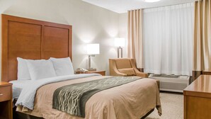A hotel room with a large bed, a chair, a desk, and a window with curtains. - Comfort Inn Idaho Falls I-15 (Idaho Falls)