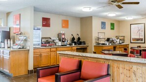 A hotel kitchen with a bar area, red cushioned seating, and a ceiling fan. - Comfort Inn Idaho Falls I-15 (Idaho Falls)