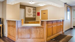 A hotel reception area with a wooden reception desk, a sign reading "Comfort Inn," and a door labeled "Lobby." - Comfort Inn Idaho Falls I-15 (Idaho Falls)