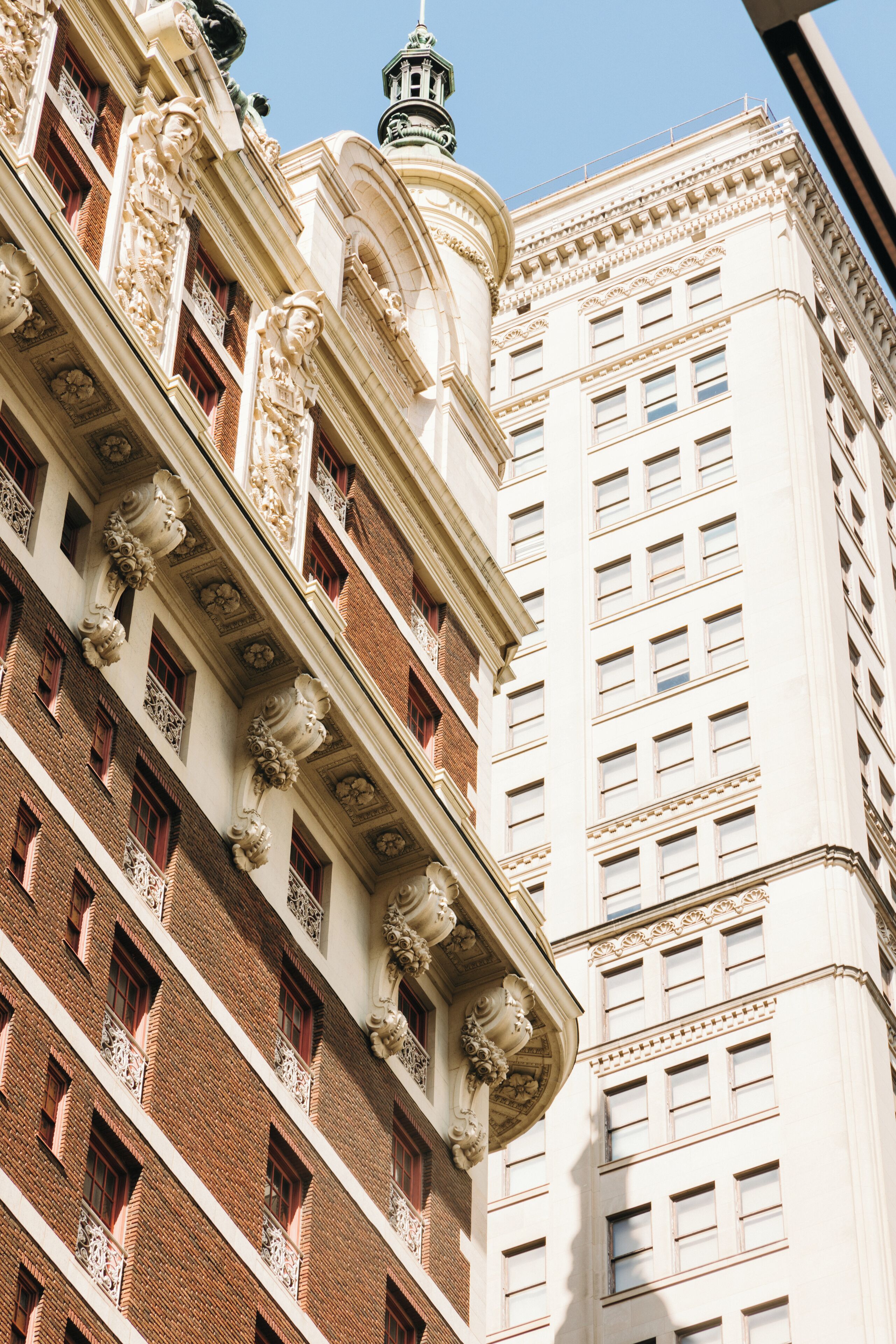 A multi-story building with ornate architectural details, including decorative balconies and a spire.