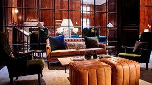Un interior moderno con un sofá de cuero, sillones y una mesa de centro.
