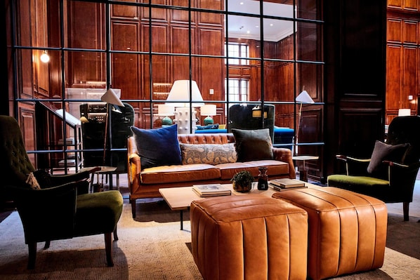 A modern interior with a leather sofa, armchairs, and a coffee table.