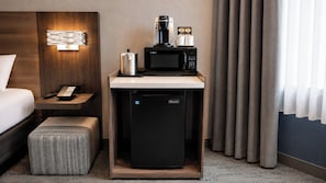 A compact kitchenette with a microwave, coffee maker, and a small refrigerator.