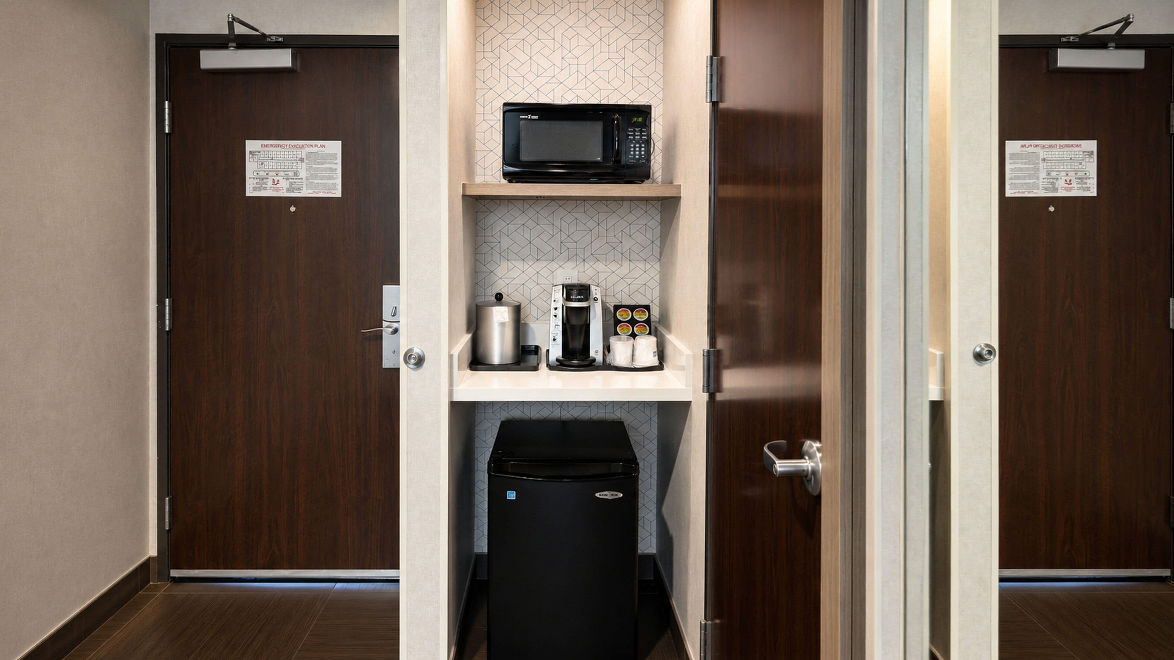 A hotel restroom with a microwave, coffee maker, and trash bin.