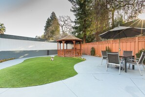 A backyard with a wooden gazebo, a patio table with chairs, and a well-maintained lawn. - Holiday Inn Express Mountain View - S Palo Alto by IHG (Mountain View)