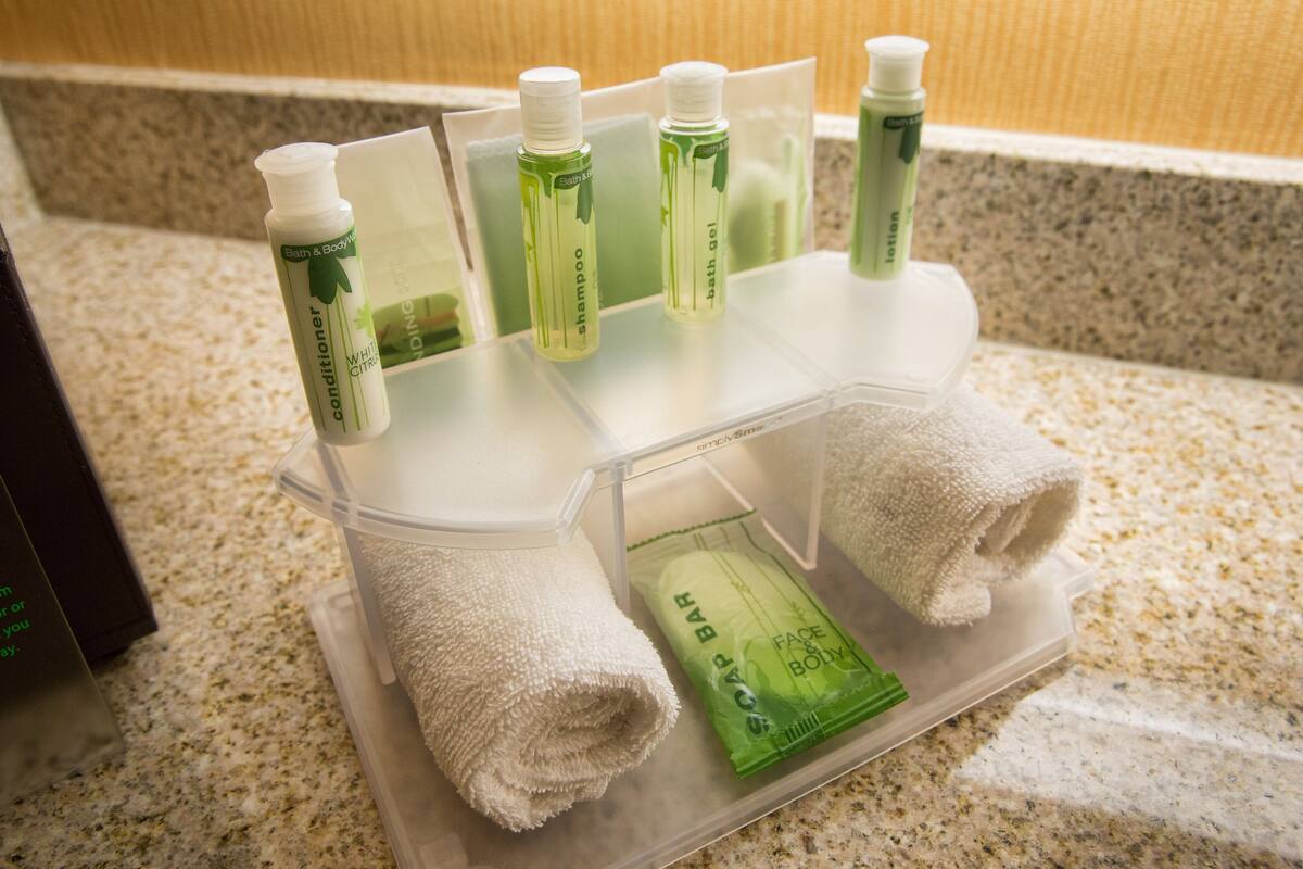 A bathroom counter with toiletries including shampoo, conditioner, and lotion.